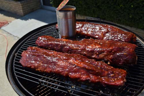 Ribs sizzling on the grill, with perfect grill marks and a mouthwatering aroma