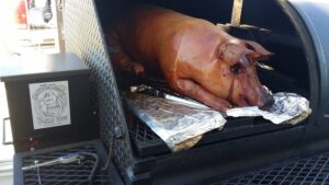 Whole pig roasting on the smoker, a spectacle of slow-cooked perfection