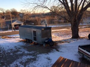 BBQ trailer surrounded by snow, a winter scene highlighting the resilience of outdoor cooking.