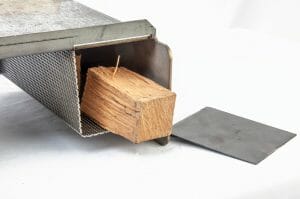 Perforated heat diffuser in pellet grill, designed for optimal heat distribution and smoke infusion. Perfect for placing wood chips or chunks, enhancing flavor profiles during cooking