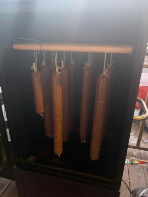 Sausage links hanging in the smoker – a smoky spectacle of savory goodness in the making