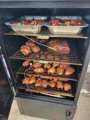 Assortment of delectable foods in a large cabinet smoker – a symphony of flavors awaiting the smoky embrace