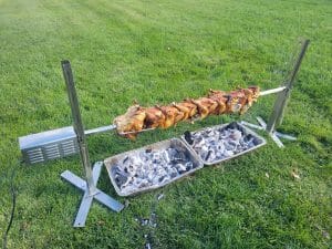 Rotisserie Perfection: Chickens Cooking Over Glowing Coals