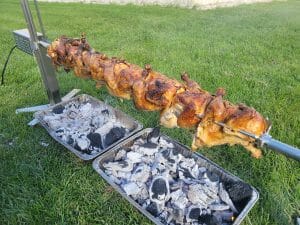 Rotisserie Perfection: Chickens Cooking Over Glowing Coals