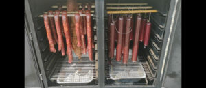 Hanging sausages in a large smoker, a scene of flavor and tradition in the making.