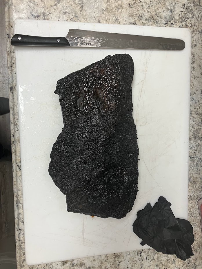 Succulent brisket resting on a cutting board, poised for the knife to unveil its tender perfection in each savory slice